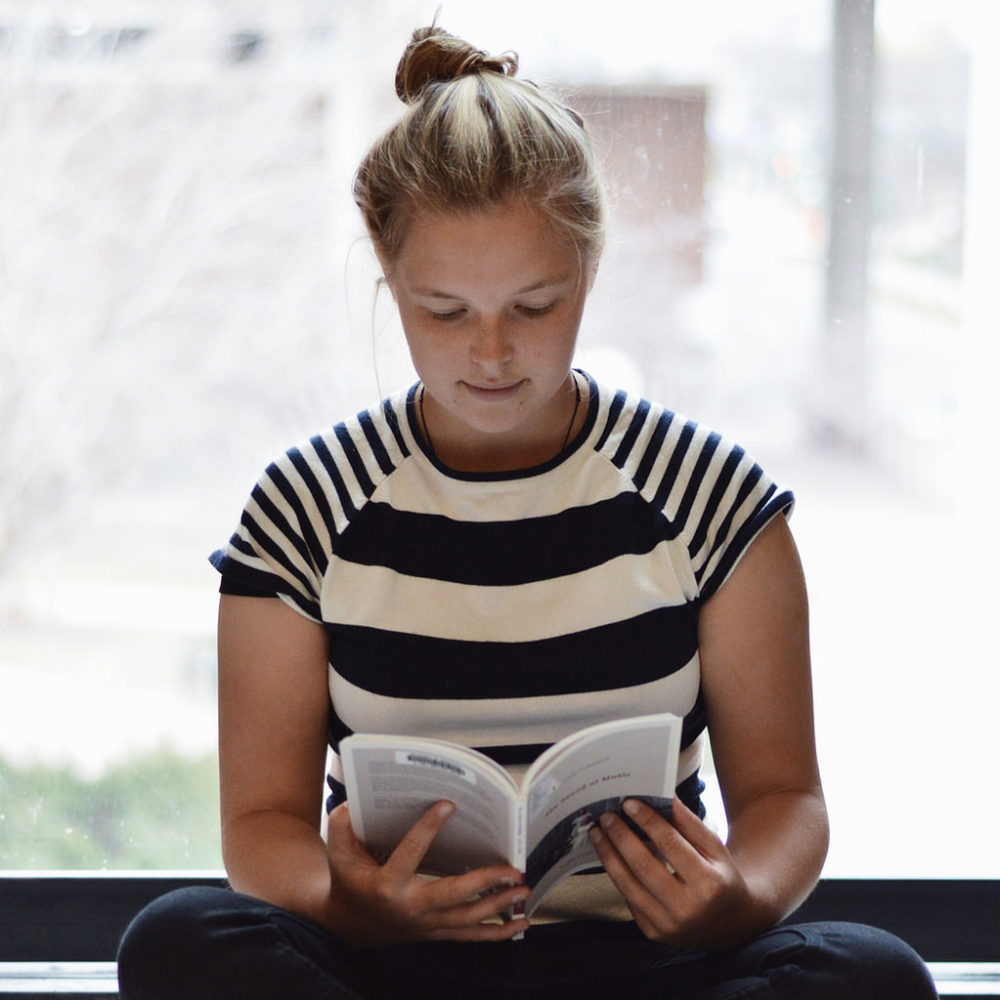 Photo by Maria Soroka: "Laura reading 'The Sound of Music' on a quiet afternoon in Wilson Library."