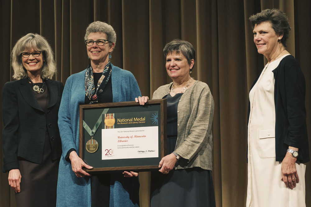 Wendy Lougee and Jennifer Gunn accept the National Medal for Museum and Library Service. At far left is Dr. Kathryn K. Matthew, director of the Institute of Museum and Library Services. At far right is Cokie Roberts, Journalist and Commentator for National Public Radio and ABC News.