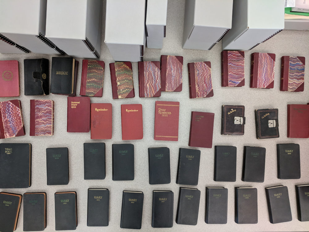 Overhead view of all 44 of Tometaro Kitagawa's diaries spread across a table before being processed.