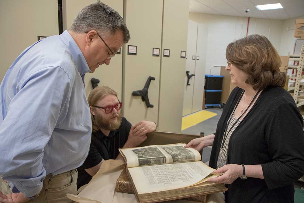 J. B. Shank, Luke Freeman, and Maggie Ragnow examine the latest acquisition of "Ceremonies."