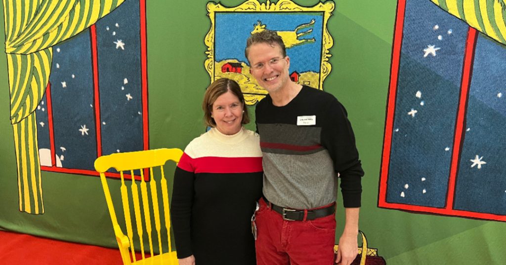 two people posing in front of the backdrop for the children's book "Goodnight Moon"