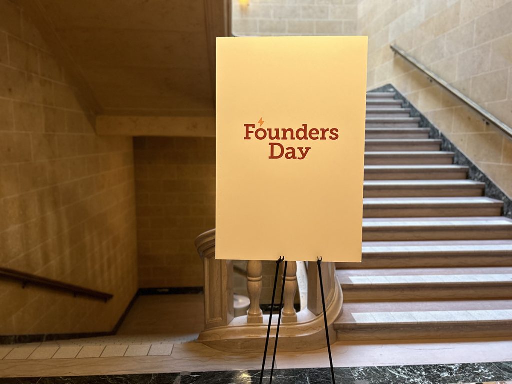 Large white sign on an easel that reads, "Founders Day"