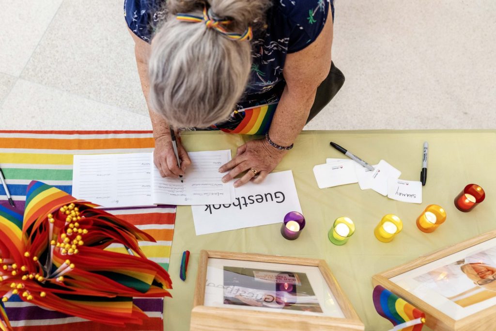 An attendee signs the guestbook for the celebration of life for Jean-Nickolaus Tretter on Friday, June 23, 2023, in the Elmer L. Andersen Library. (Photo/Adria Carpenter)