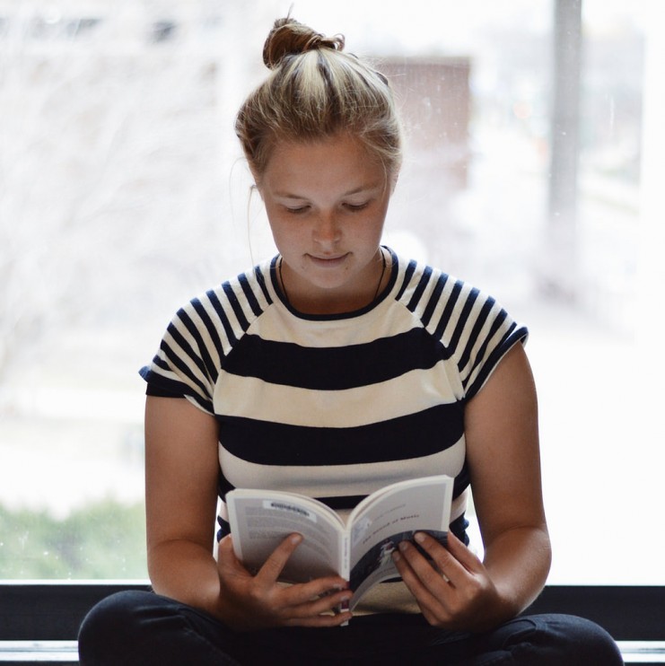 Photo by Maria Soroka: "Laura reading 'The Sound of Music' on a quiet afternoon in Wilson Library."