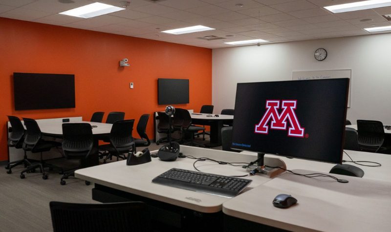 Desks and computers in a large classroom. 