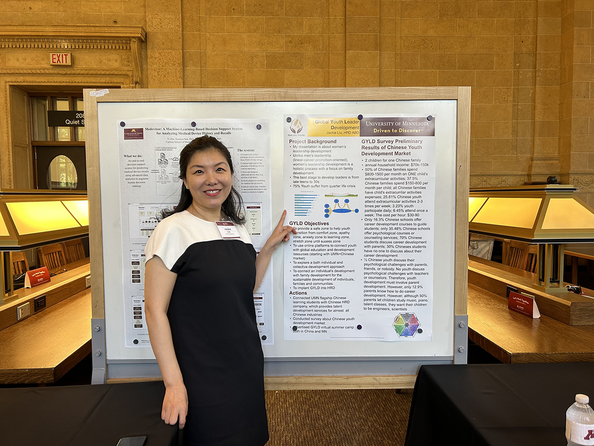 Jackie standing in front of her Global Youth Leader Development poster at Founders Day.