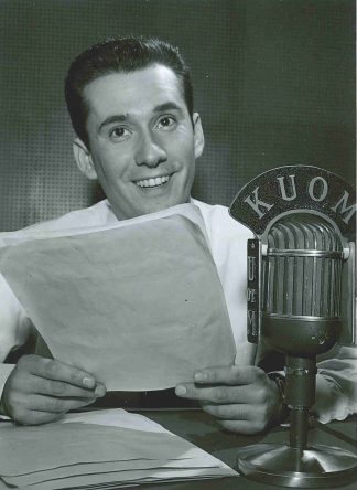 Unidentified man with KUOM microphone. University of Minnesota Radio and Television Broadcasting records, University Archives