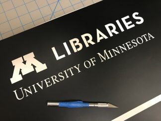 Graph Designer Aaron Groh prepares the vinyl stencil.