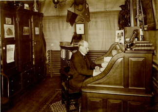 Photo of Robert R. McBurney, the “first paid secretary” of the YMCA sitting at his desk.