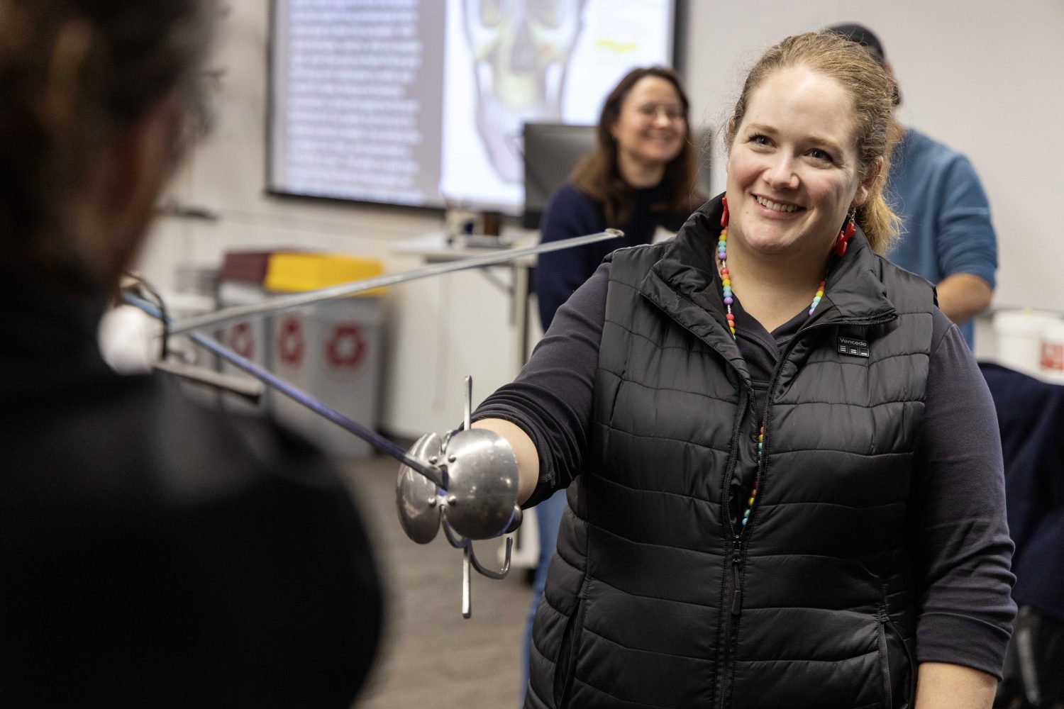 Emily Beck learns how to duel with swords at the Wangensteen pop-up exhibit.