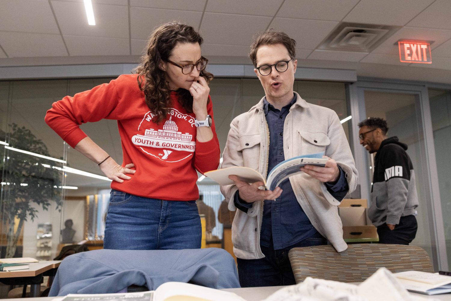 Lindsey Pullum, program director of YMCA Youth and Government, and Cody Hennesy, a computational research librarian at the University of Minnesota, read a book from the Kautz Family YMCA Archives, on Wednesday, April 17, 2024. (Photo/Adria Carpenter)