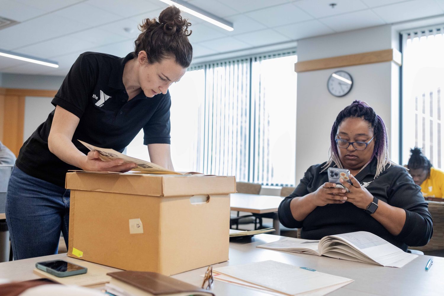 Lindsey Pullum, program director of YMCA Youth and Government, and Jocelyn Woods, teen leadership program director at YMCA of Greater Oklahoma City, Oklahoma, scan through folders from the Kautz Family YMCA Archives, on Wednesday, April 17, 2024. (Photo/Adria Carpenter)