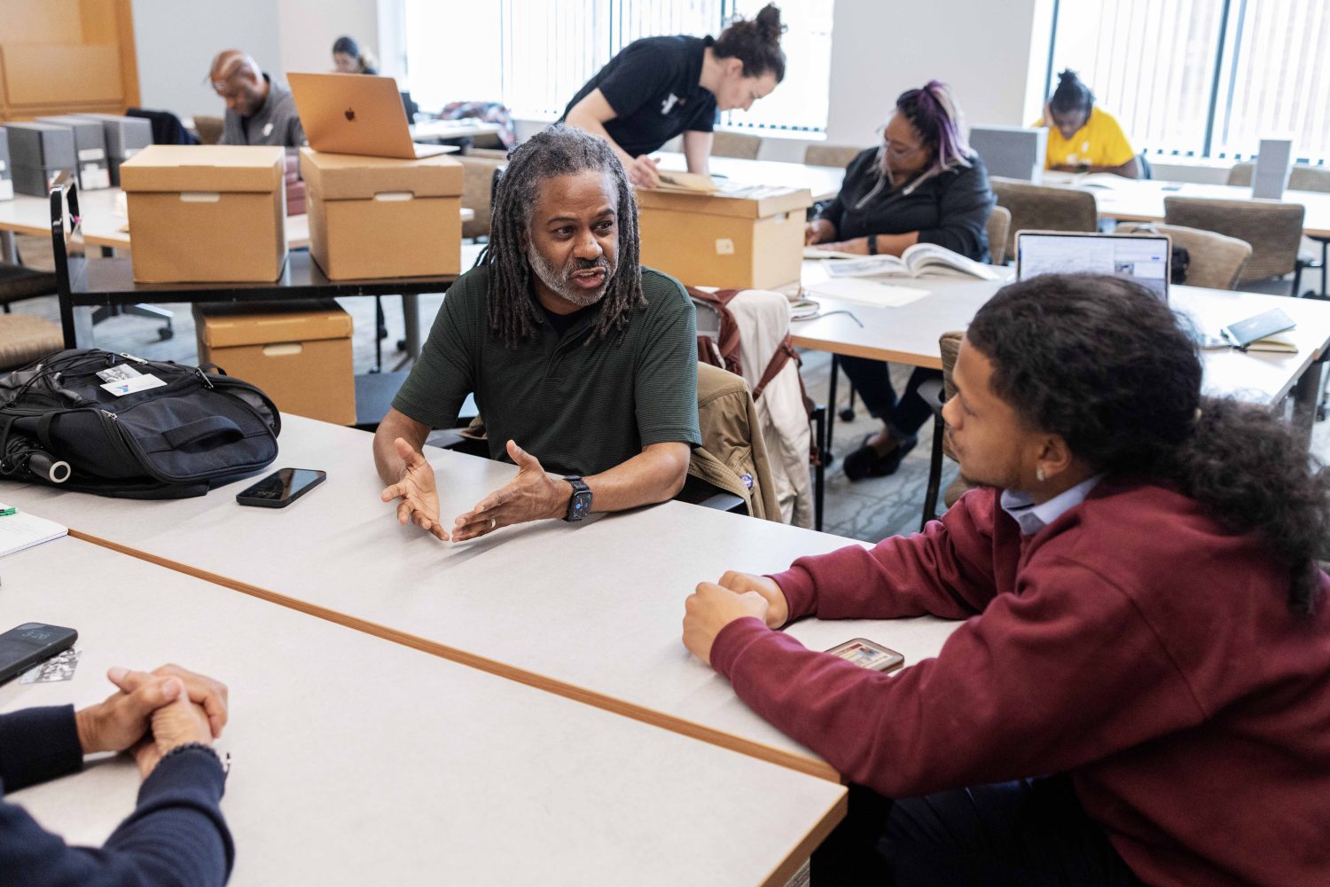 Morris "Dino" Robinson Jr., author of "Gatherings: The History and Activities of the Emerson Street Branch YMCA," talks with Elijah Megginson, a junior English major at Morehouse College, on Wednesday, April 17, 2024. (Photo/Adria Carpenter)