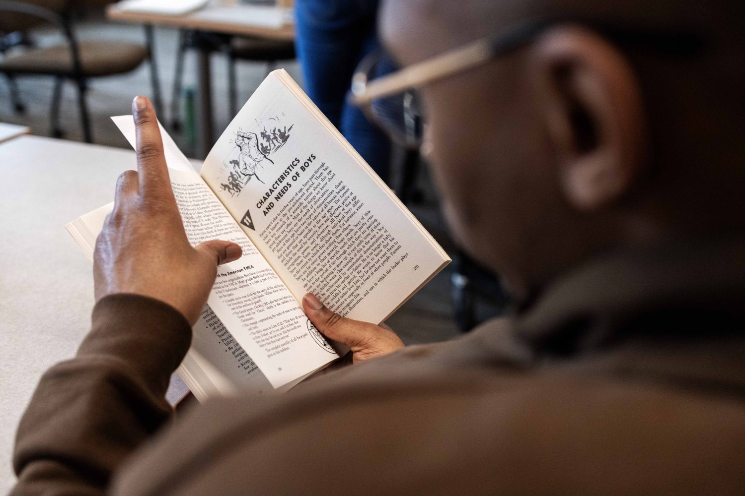 Quentin Francis, director of youth development at the Ann Arbor YMCA in Michigan, reads a book from the Kautz Family YMCA Archives, on Wednesday, April 17, 2024. (Photo/Adria Carpenter)