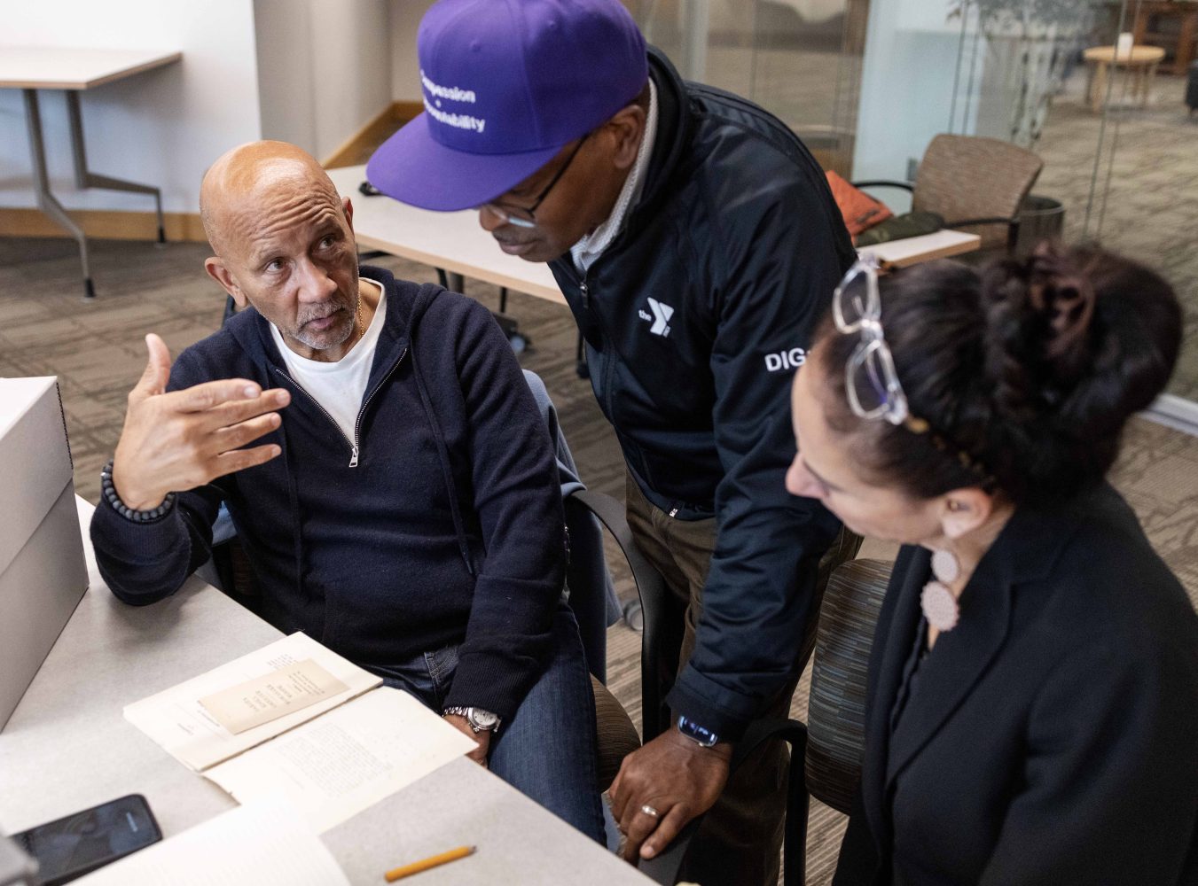 Charles Collins, president emeritus of the YMCA of San Francisco, Michael DeVaul, national director of Boys and Young Men of Color, and Charlene Lyons, president of YMCA of the Treasure Coast in Stuart, Florida, talk in the Kautz Family YMCA Archives, on Wednesday, April 17, 2024. (Photo/Adria Carpenter)