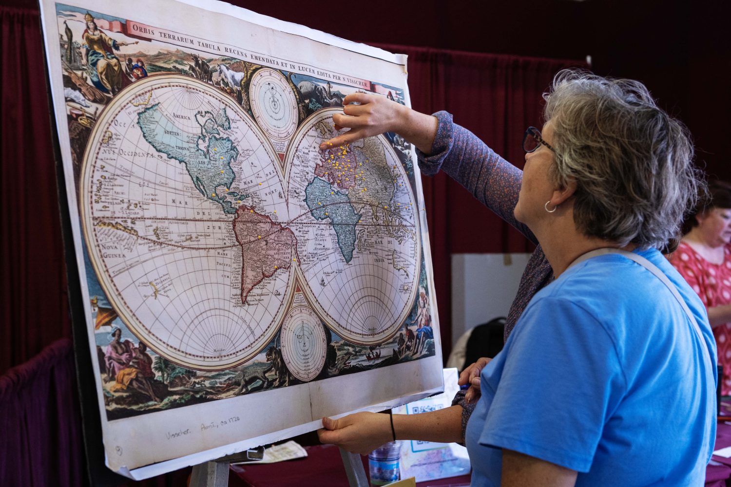 An attendee places a pin on the map to mark where she thinks her ancestors originated from, at the Center for Premodern Studies' booth at the Minnesota State Fair on Thursday, August 29, 2024. (Photo/Adria Carpenter)