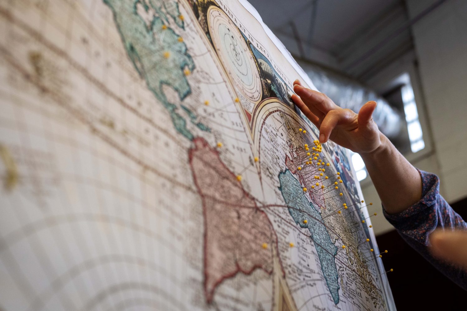 An attendee places a pin on the map to mark where she thinks her ancestors originated from, at the Center for Premodern Studies' booth at the Minnesota State Fair on Thursday, August 29, 2024. (Photo/Adria Carpenter)