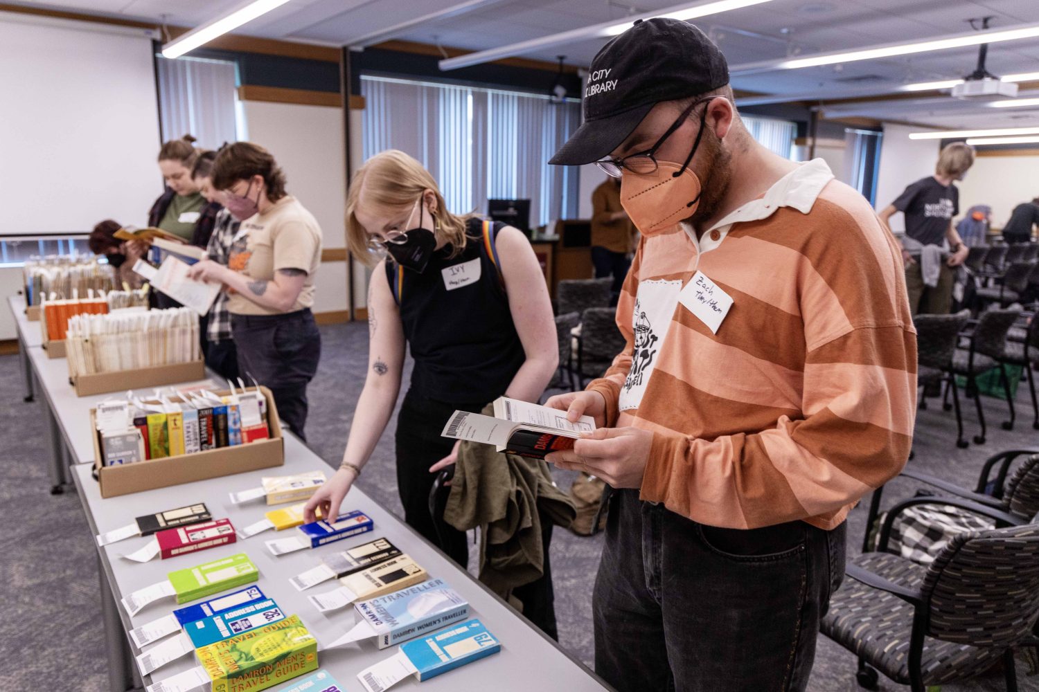 Attendees look at zines from the Tretter Collection during the Midwest Queer and Trans Zine Fest conference at Andersen Library in Minneapolis on Friday, October 18, 2024. (Photo/Adria Carpenter)