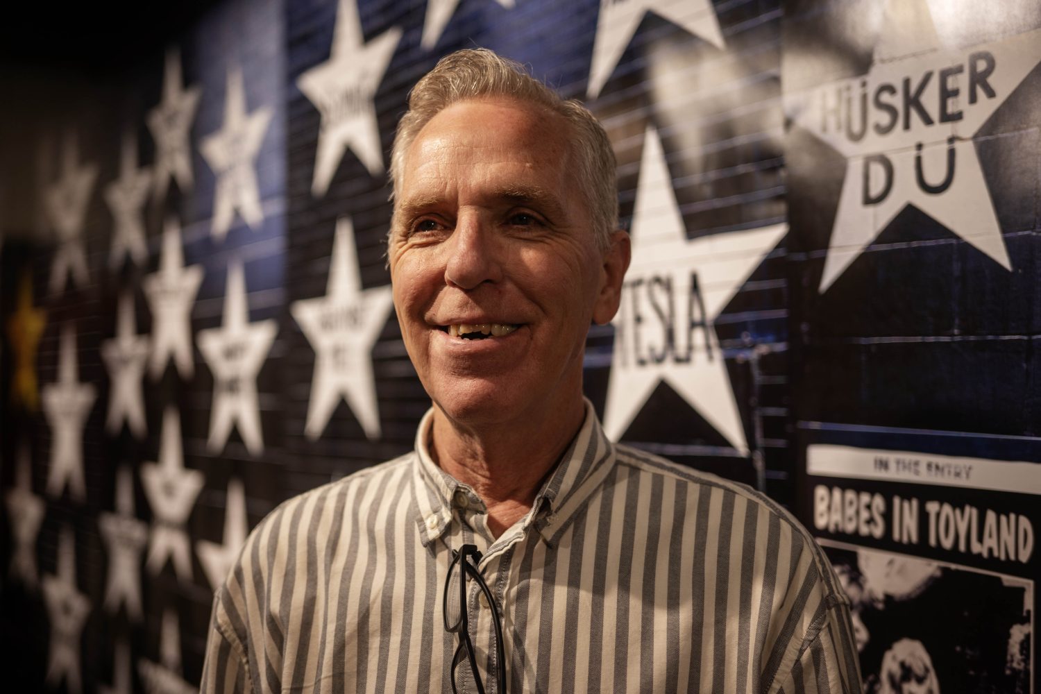 Tim Carroll, the preservation society manager and archivist for Hennepin Arts, poses for a portrait in front of the First Avenue and 7th St. Entry "wall of stars," in the "Music on Hennepin" exhibit, on Monday, December 9, 2024. (Photo/Adria Carpenter)