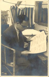 Werner Simon as a young man, sitting outdoors and reading sheet music