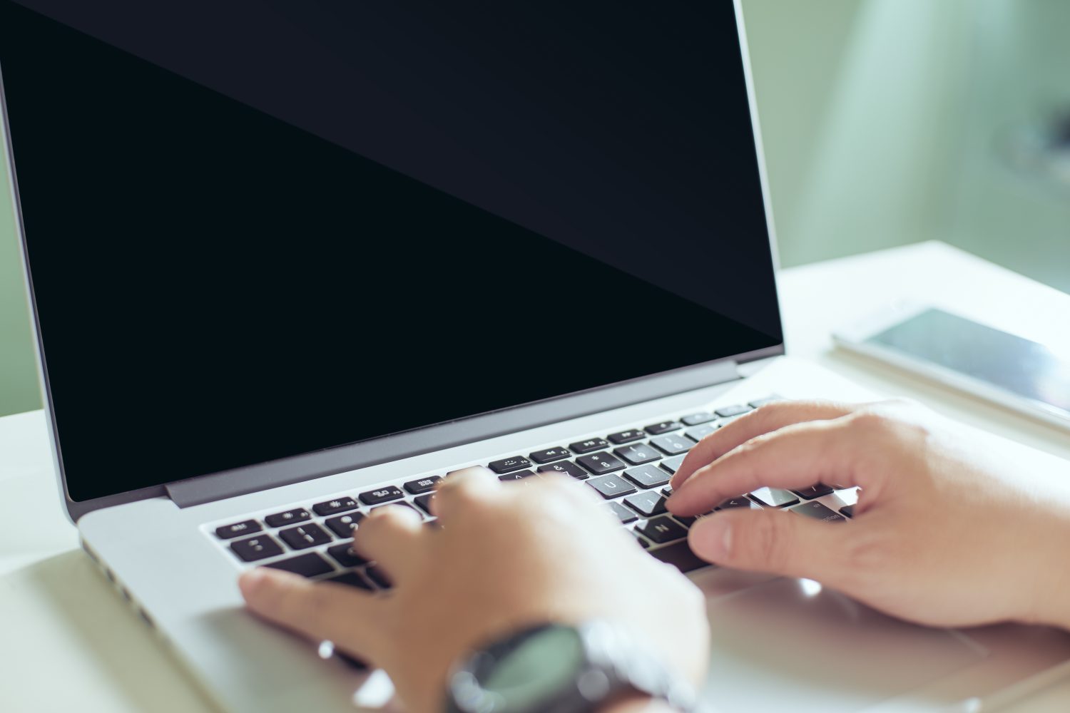 Person typing on keyboard of open laptop