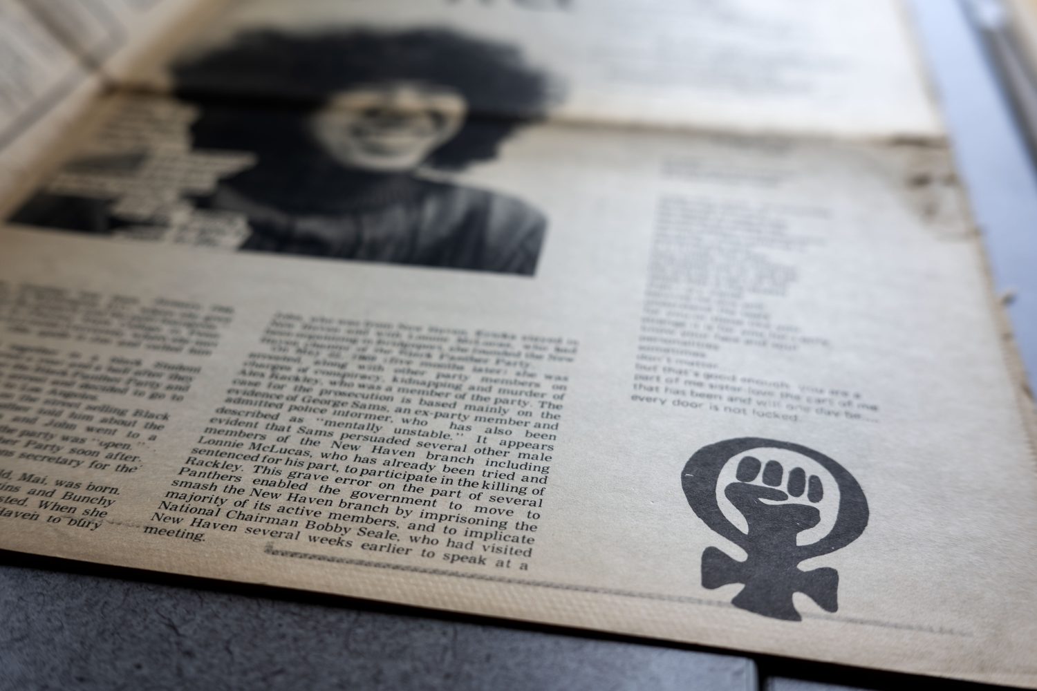 Raised fist inside the Venus symbol on newsprint