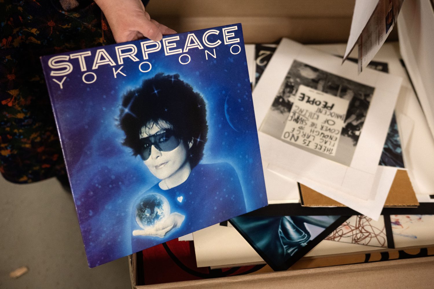 Woman in space, wearing sunglasses, holding a sphere.