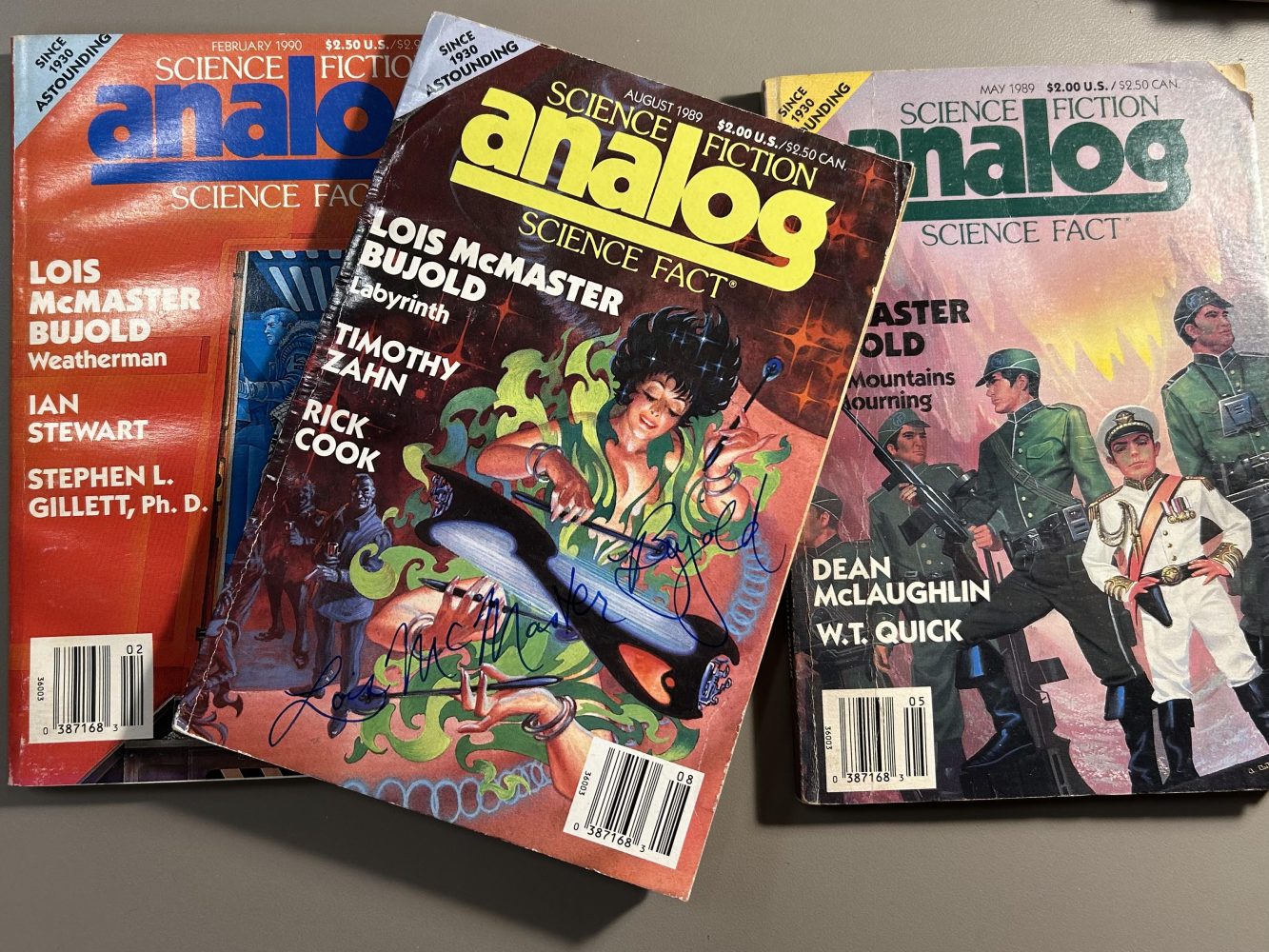 Science fiction magazine covers featuring men in military attire and a witchy woman.
